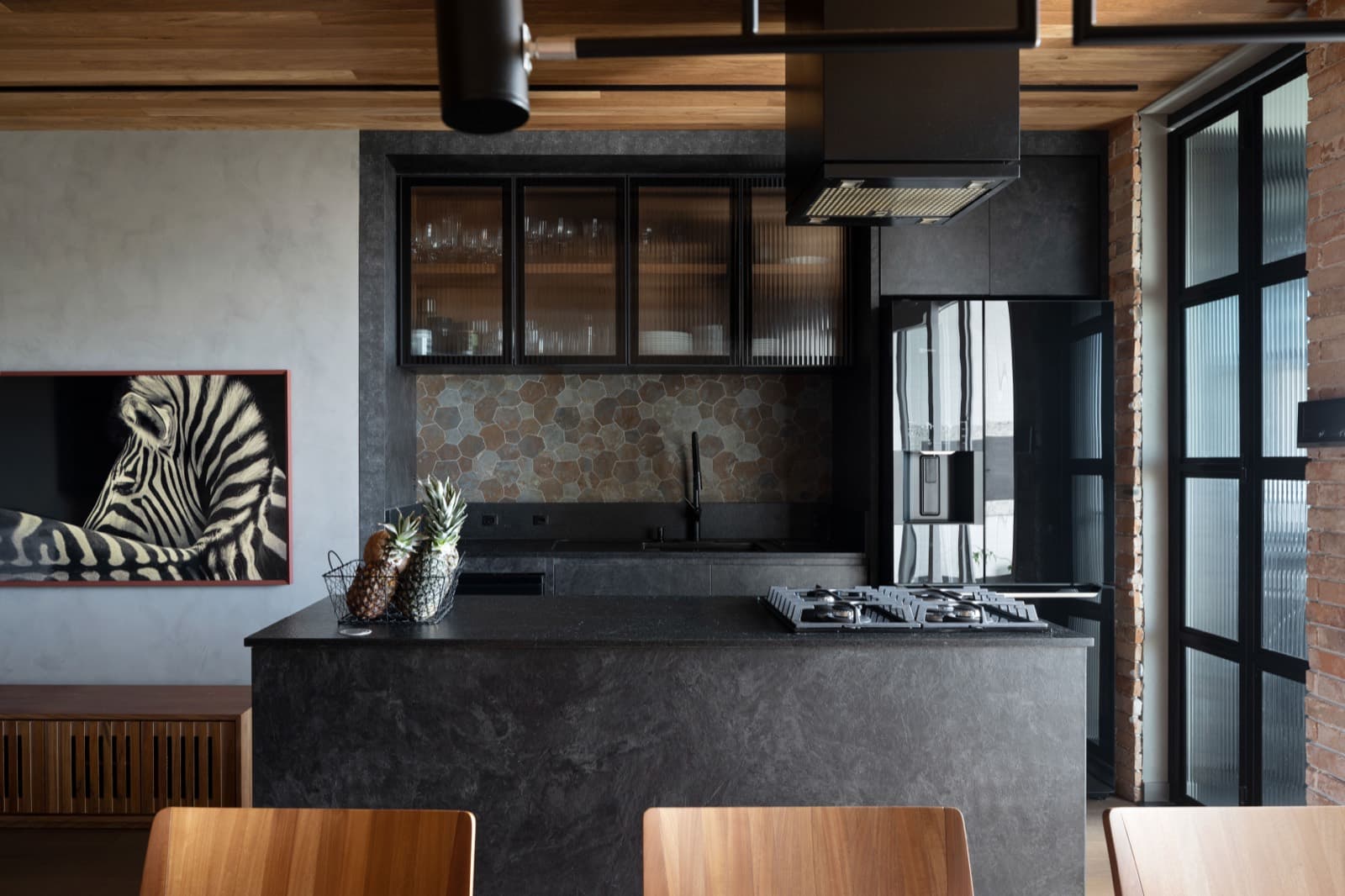 Ilha de cozinha em pedra escura com cooktop integrado