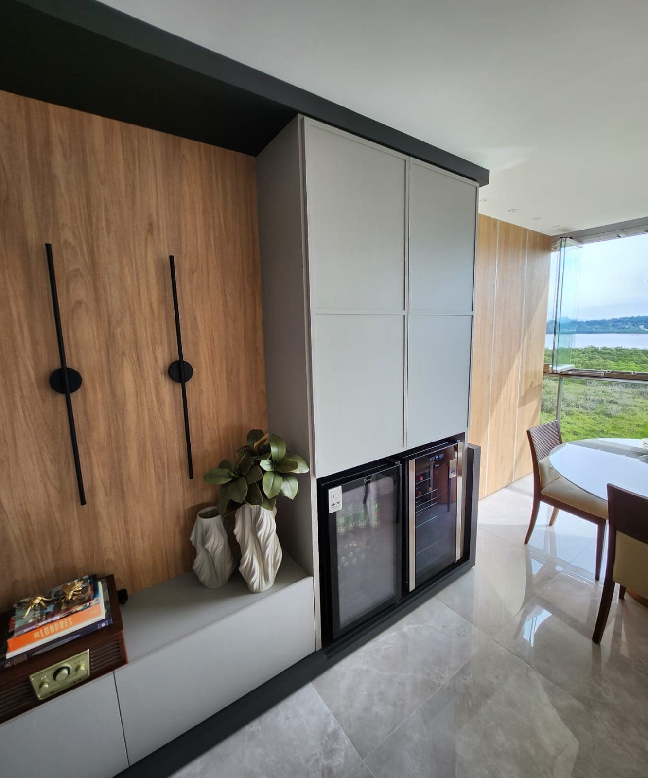 Adega e armários brancos com vista para o mar