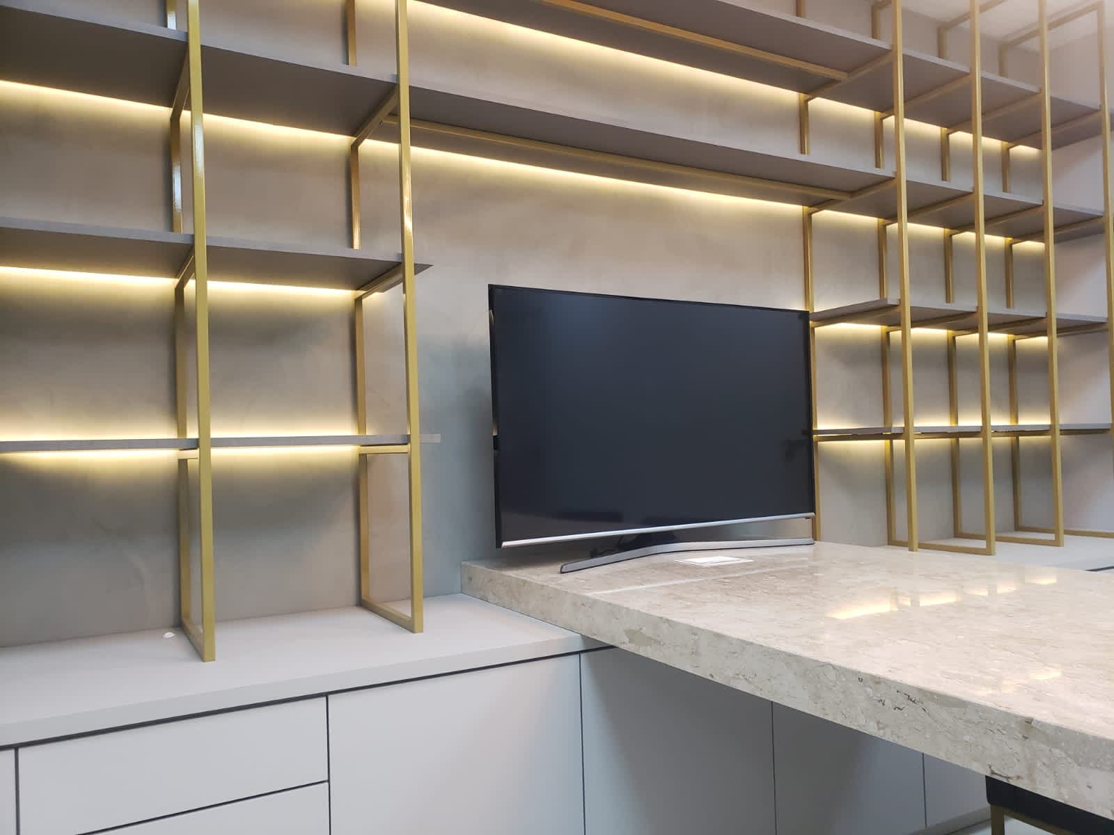 Estantes metálicas douradas com iluminação embutida