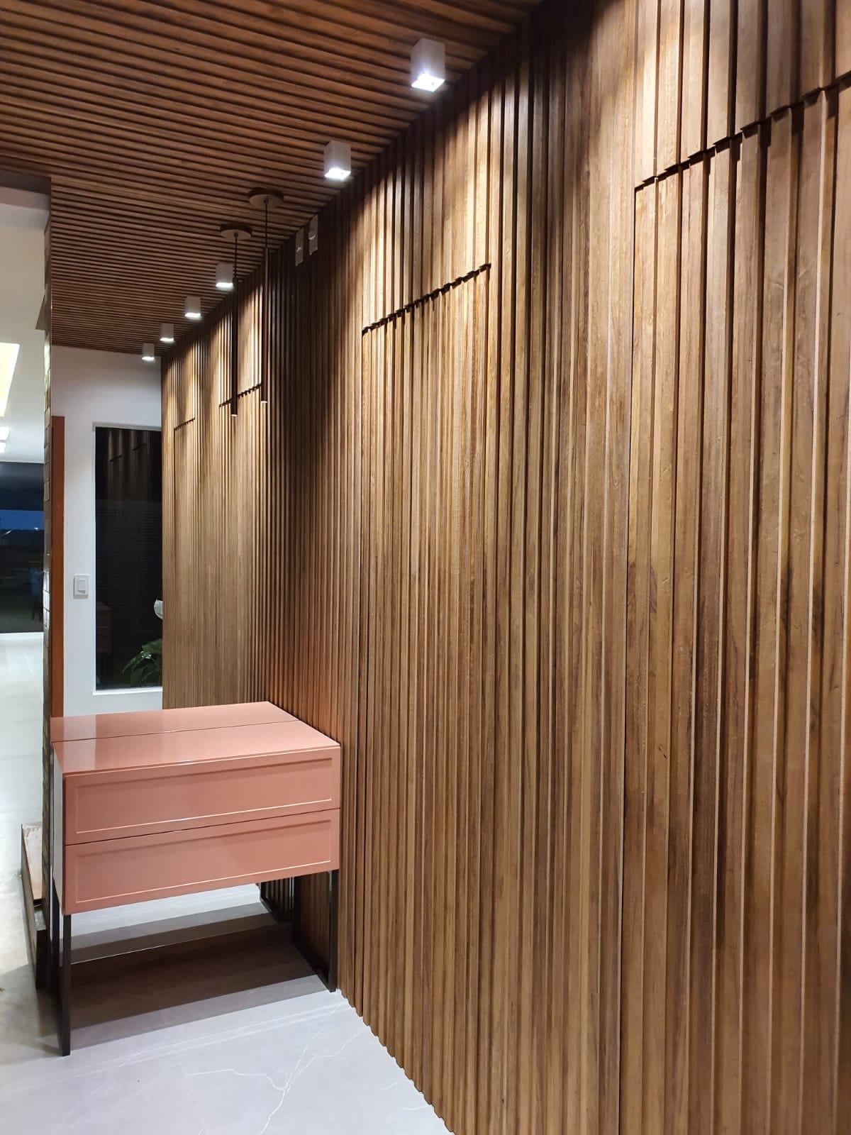 Hall de entrada em ripado de madeira maciça com aparador